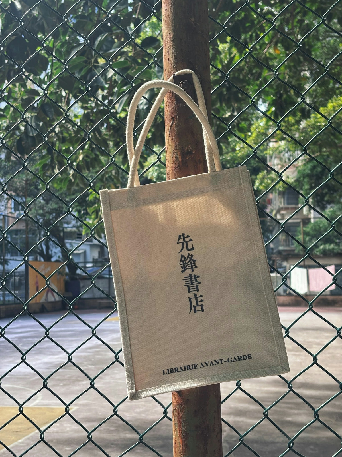 A canvas tote bag hangs on a pole.