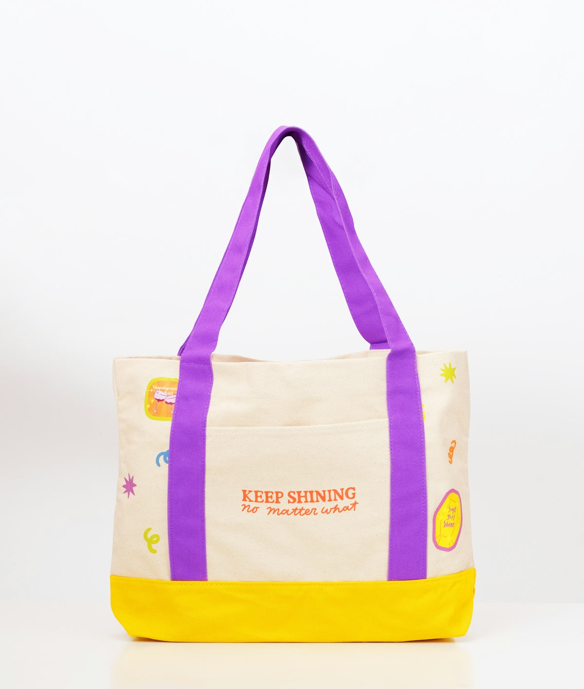 Beige canvas tote bag with keep shining text and doodles.